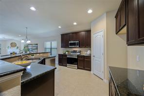 Kitchen featuring appliances with stainless steel finishes, tasteful backsplash, light tile flooring, and a kitchen island