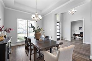 Home office featuring crown molding, a tray ceiling, and wood-style floors