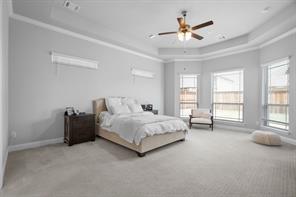 Primary Bedroom with tray ceiling, ceiling fan