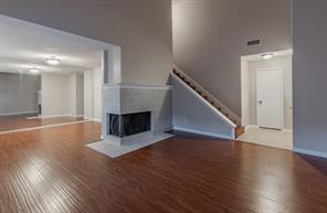 Unfurnished living room with a textured ceiling, wood-type flooring, and a skylight