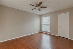 Bedroom with a textured ceiling, ceiling fan, and wood-type flooring