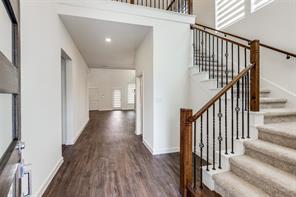 Unfurnished living room with an inviting chandelier, a towering ceiling, a high end fireplace, and dark hardwood / wood-style flooring