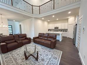 Unfurnished living room featuring a high ceiling, a tiled fireplace, a chandelier, and dark hardwood / wood-style flooring