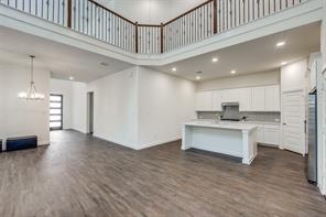 Kitchen featuring an island with sink, stainless steel appliances, dark hardwood / wood-style floors, and white cabinetry