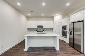 Kitchen featuring a kitchen island with sink, white cabinetry, dark hardwood / wood-style flooring, sink, and appliances with stainless steel finishes