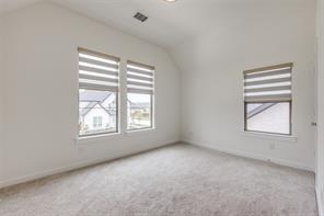 Additional living space with light carpet and vaulted ceiling