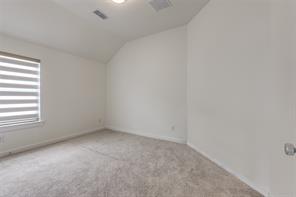 Empty room with carpet and vaulted ceiling