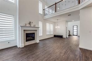 Living room featuring a notable chandelier, a towering ceiling, dark wood-type flooring, and sink