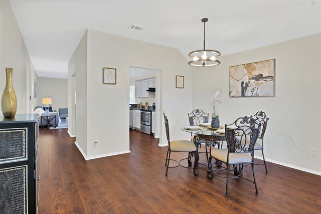 Dining area featuring an inviting chandelier and dark hardwood / wood-style floors