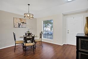 Dining space with an inviting chandelier and dark wood-type flooring