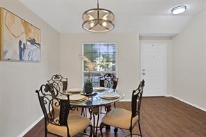 Living room with wood-type flooring, vaulted ceiling, ceiling fan, and a tiled fireplace