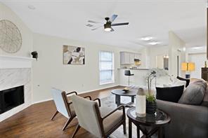 Kitchen with a breakfast bar, electric stove, kitchen peninsula, white cabinetry, and stainless steel refrigerator