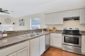 Kitchen featuring sink, white cabinetry, appliances with stainless steel finishes, dark hardwood / wood-style floors, and vaulted ceiling