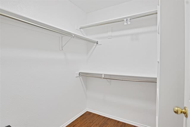Bedroom with vaulted ceiling, dark hardwood / wood-style floors, and ceiling fan
