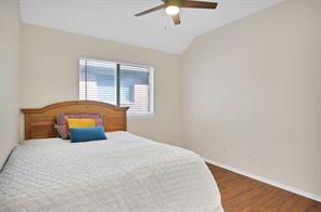 Bedroom with dark hardwood / wood-style floors, ceiling fan, and a closet