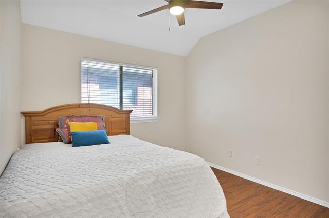 Bedroom with dark hardwood / wood-style floors, ceiling fan, and a closet