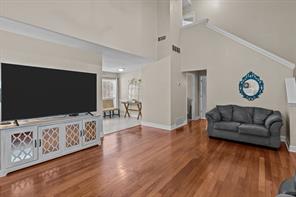 Living room with a towering ceiling and hardwood / wood-style flooring