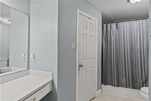 Laundry room featuring a textured ceiling, light tile patterned floors, and washer and dryer