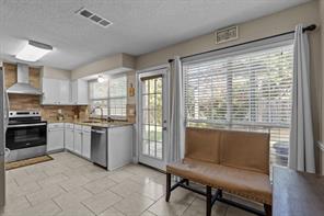 Doorway to outside with a textured ceiling and light tile patterned flooring