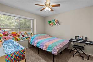 Rec room featuring light carpet, ceiling fan, and a textured ceiling