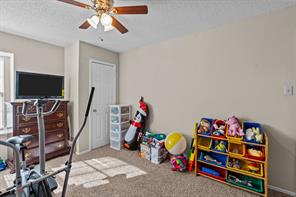 Rec room with a textured ceiling, carpet flooring, and ceiling fan