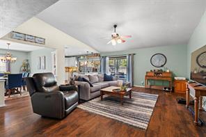 Living room featuring a textured ceiling, a fireplace, and dark hardwood / wood-style floors