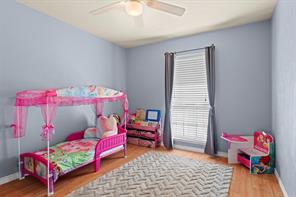 Bedroom with ceiling fan and wood-type flooring