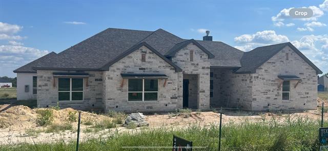 Unfurnished living room with built in shelves, a stone fireplace, vaulted ceiling, and ceiling fan