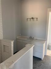 Kitchen featuring white cabinetry and sink