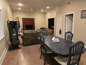 Carpeted living room featuring ceiling fan and crown molding