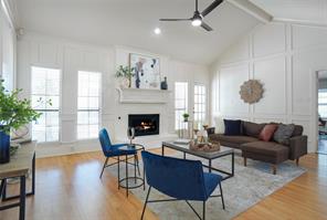 Living room featuring ceiling fan, light wood-type flooring, and lofted ceiling with beams