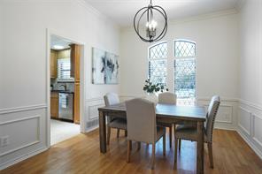 Dining room with a notable chandelier, wood-type flooring, and crown molding