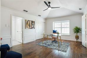 Home office featuring lofted ceiling, ornamental molding, hardwood / wood-style floors, and ceiling fan