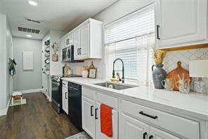 Kitchen featuring a center island, dark wood-type flooring, white cabinets, hanging light fixtures, and ceiling fan