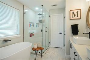 Bathroom with ceiling fan, vanity, and a bath